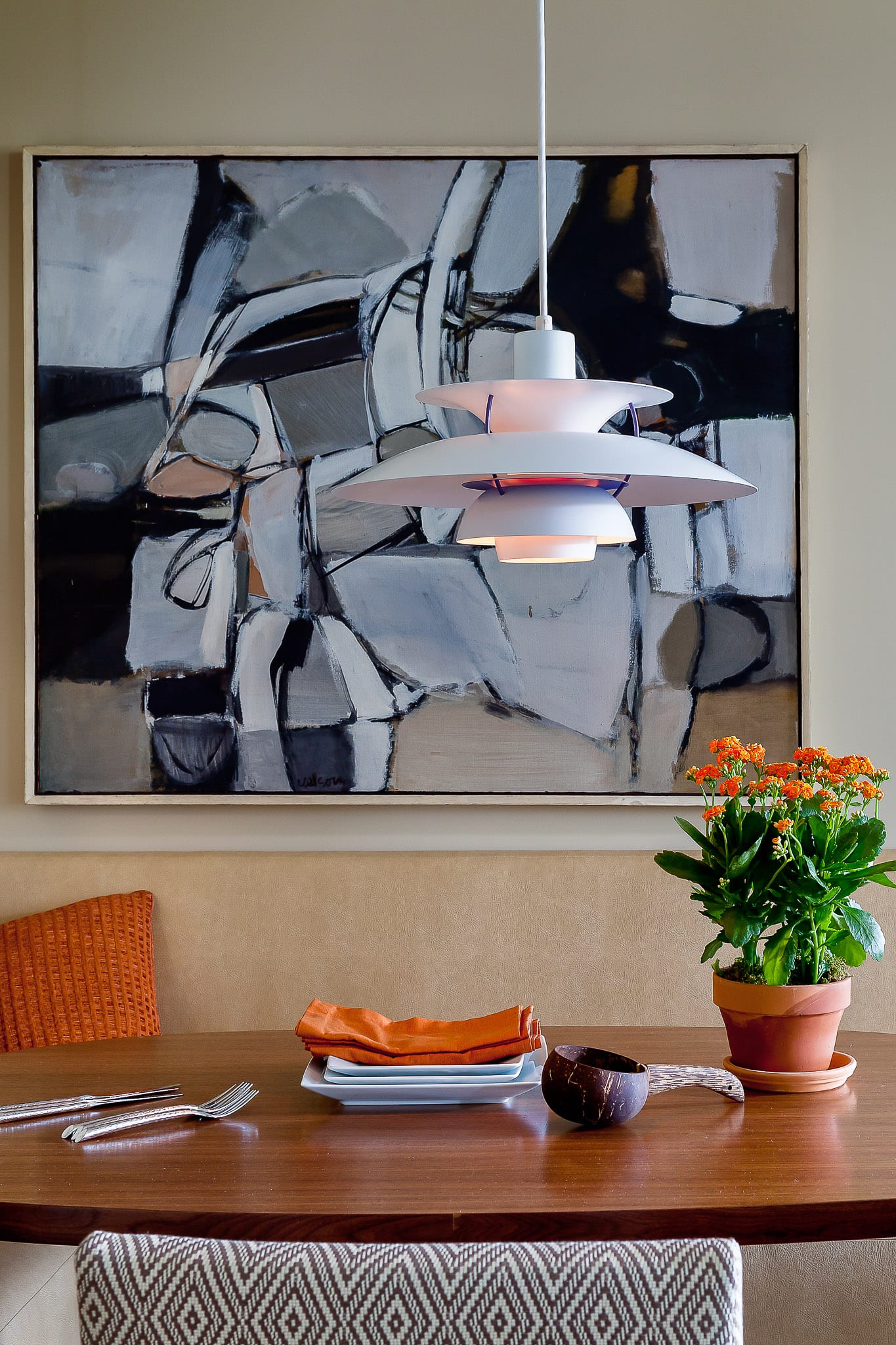A custom banquette upholstered in distressed buckskin, and “Turner” chair in Kravet’s Diamond Raffia surround a custom walnut table top from Nutech Interiors. The large late 1950’s abstract painting in grey, black and white evinces the spirit of cool jazz.