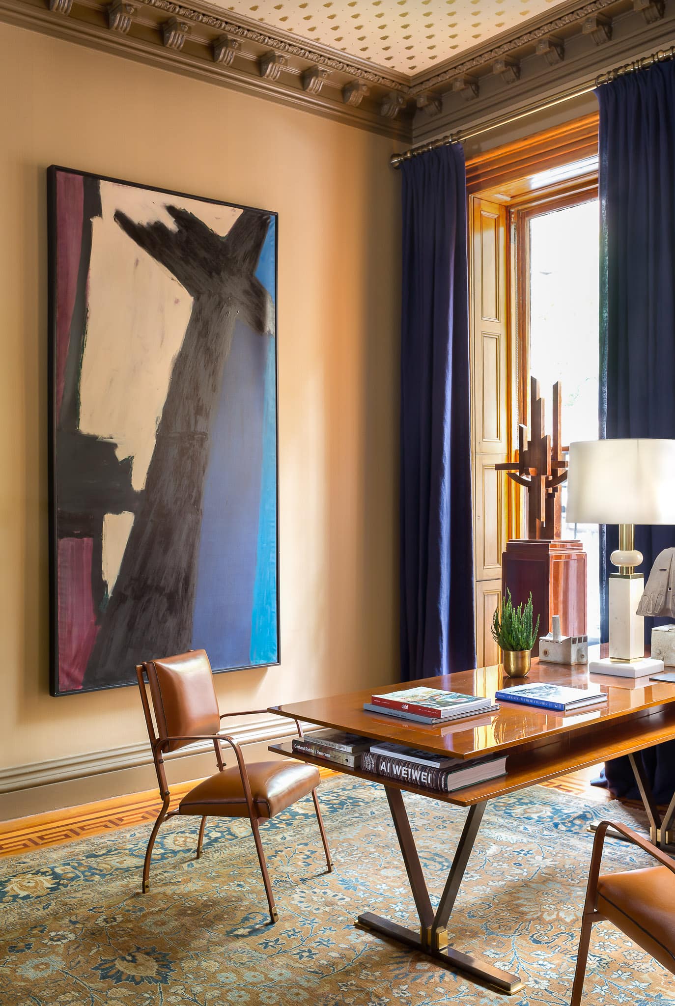 The 1959 painting by Abstract Expressionist painter Judith Godwin, entitled ‘Black Cross’, pairs beautifully with the striking Jules Leleu modernist table-desk and the pair of vintage Jacques Adnet leather-wrapped chairs. The rusted steel sculpture by Marino di Teana sits proudly on a mahogany pedestal in the window.